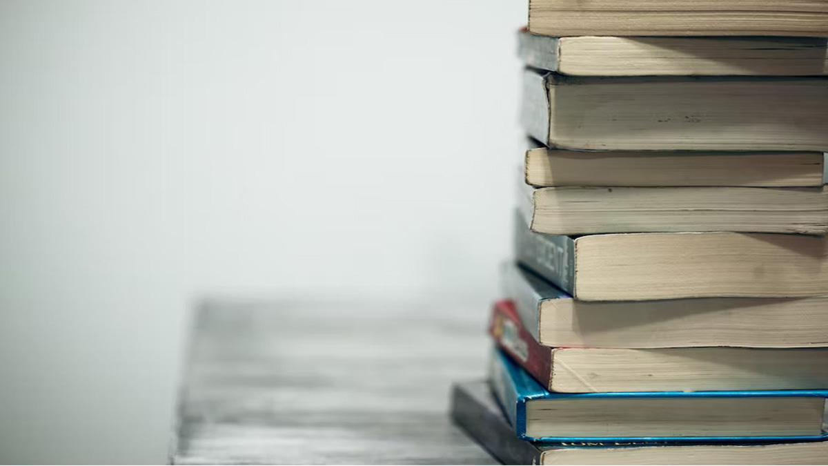 stack of books on table, bottom edge of books facing out