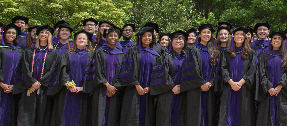 Students dressed in purple and black gowns on Convocation day