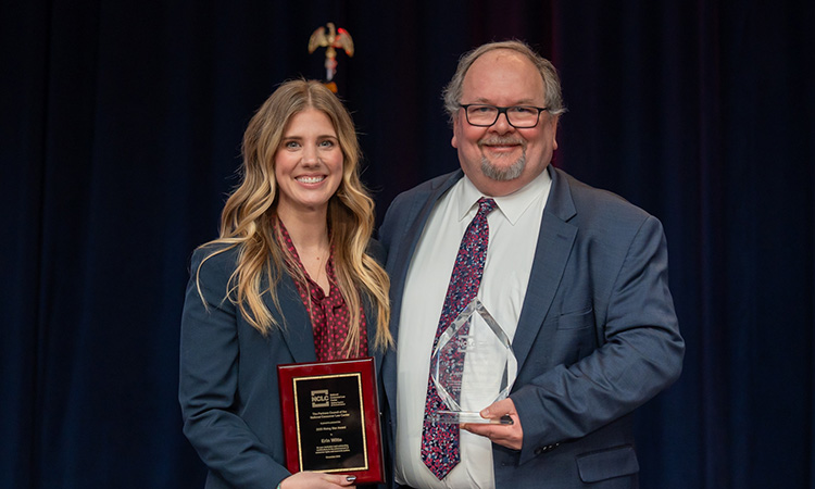 Erin Witte and Leonard A. Bennett holding their awards