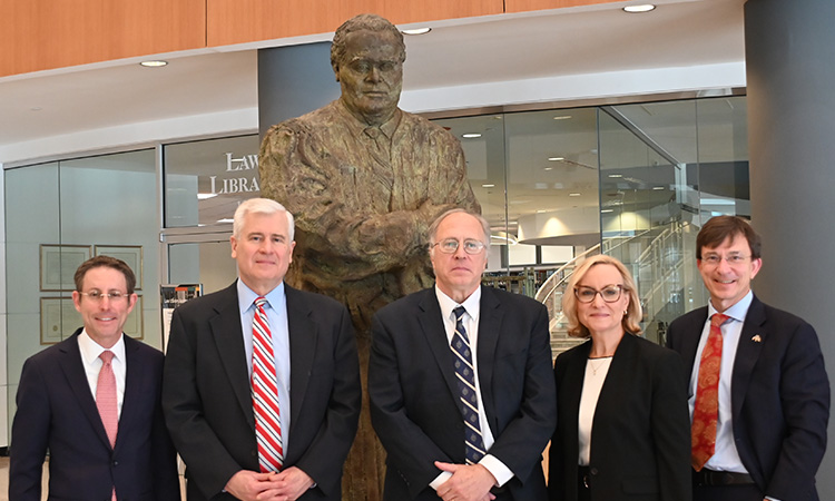 Forum members posed in row in front of Antonin Scalia statue in front of Law Library